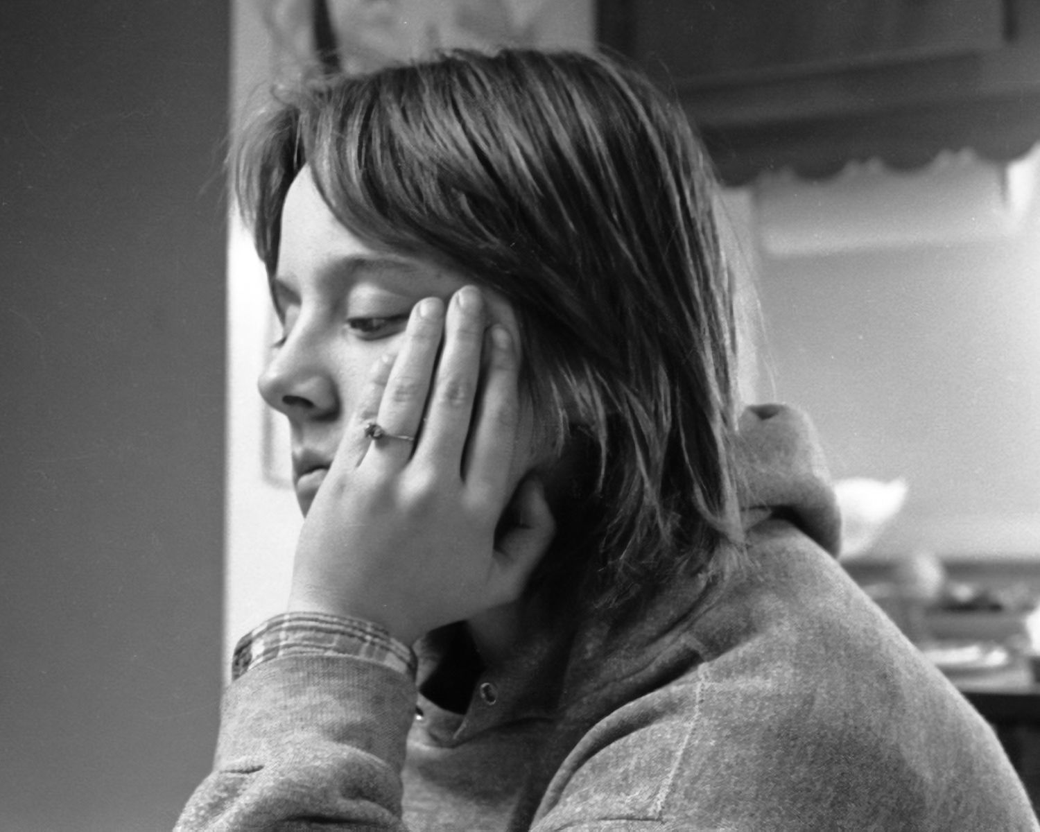 A black and white photo of a woman with her hand on her face