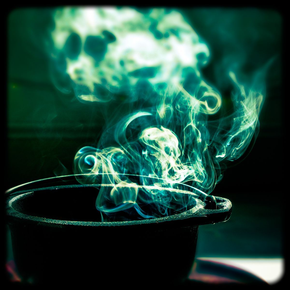 Green smoke is coming out of a black pot