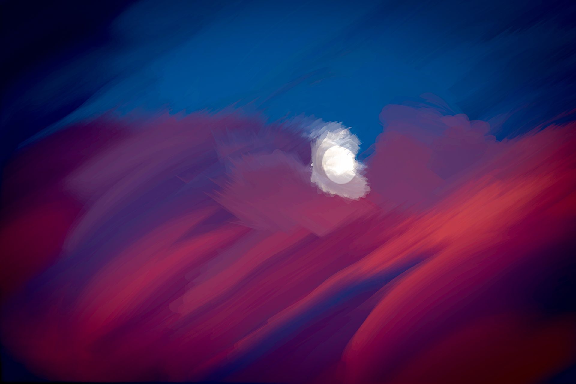 The moon is shining through the clouds in the night sky.