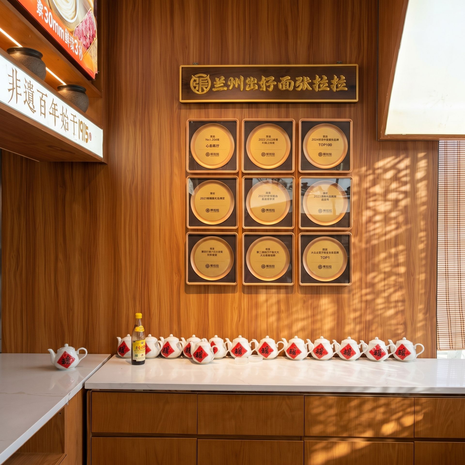 Wood-paneled awards display with gold plaques, a Chinese sign, and a row of folded red-and-white cloths on a counter