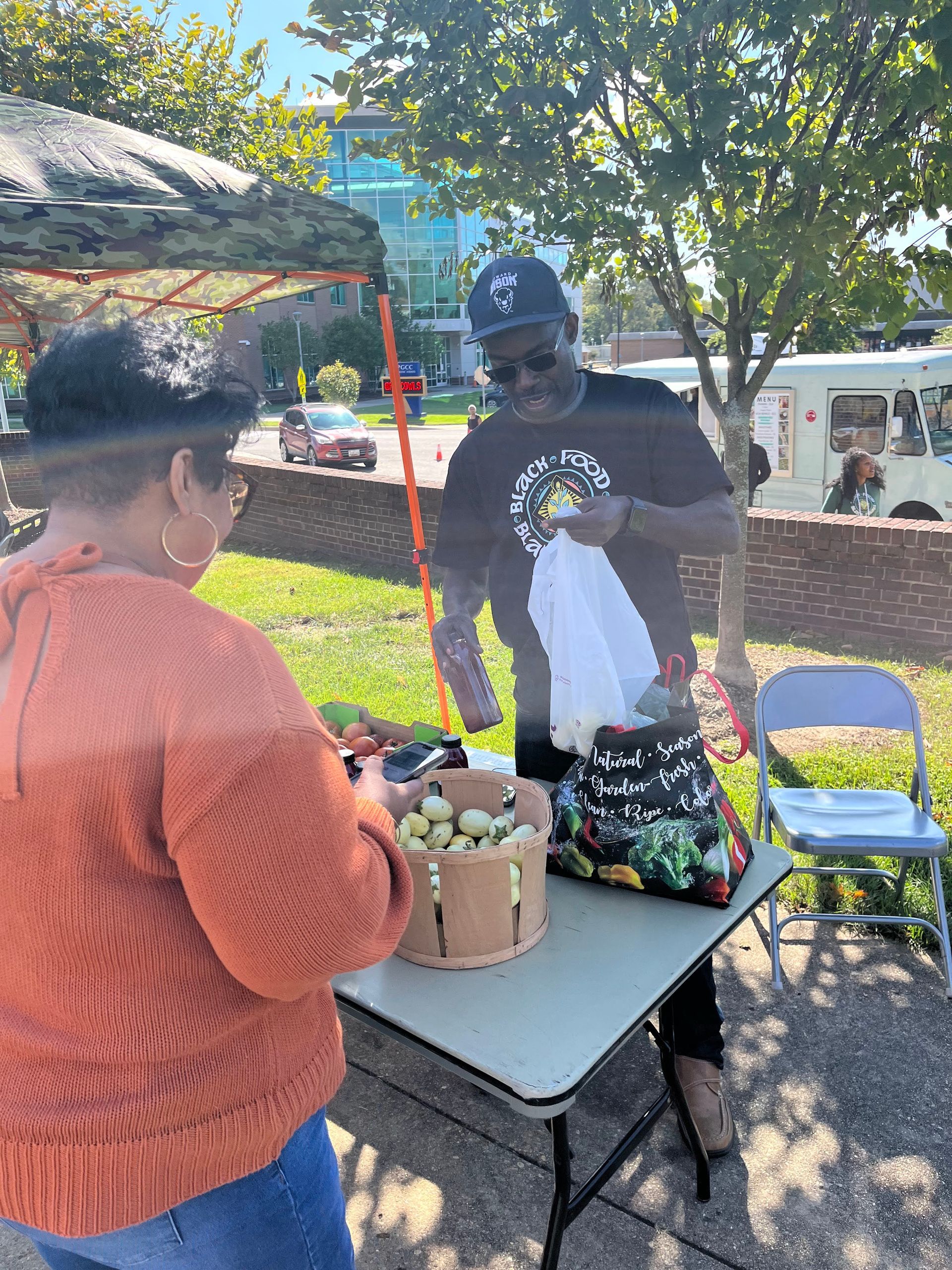 A man is selling vegetables to a woman at a table