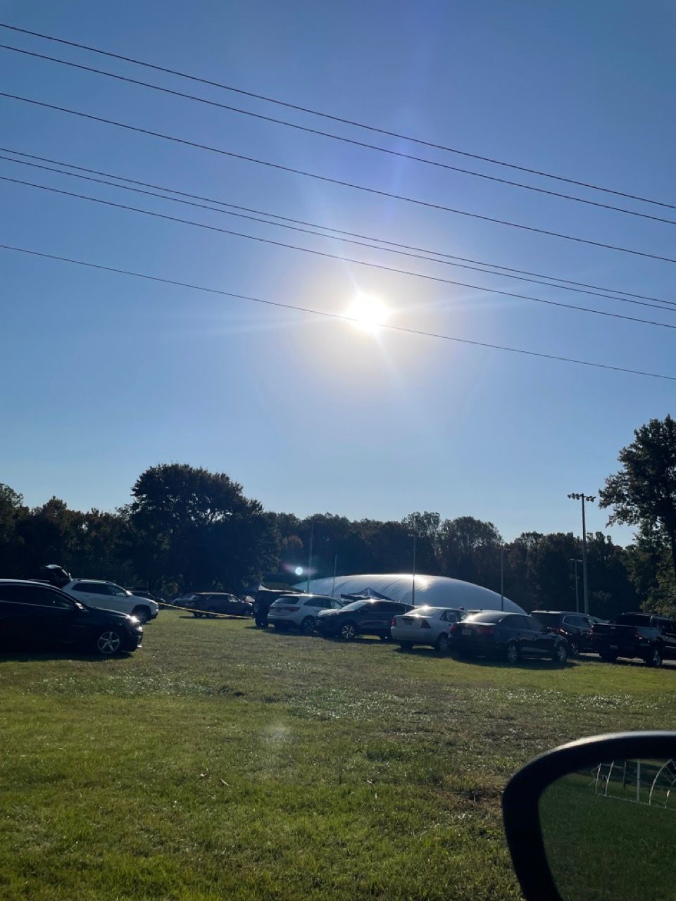 The sun is shining brightly over a parking lot
