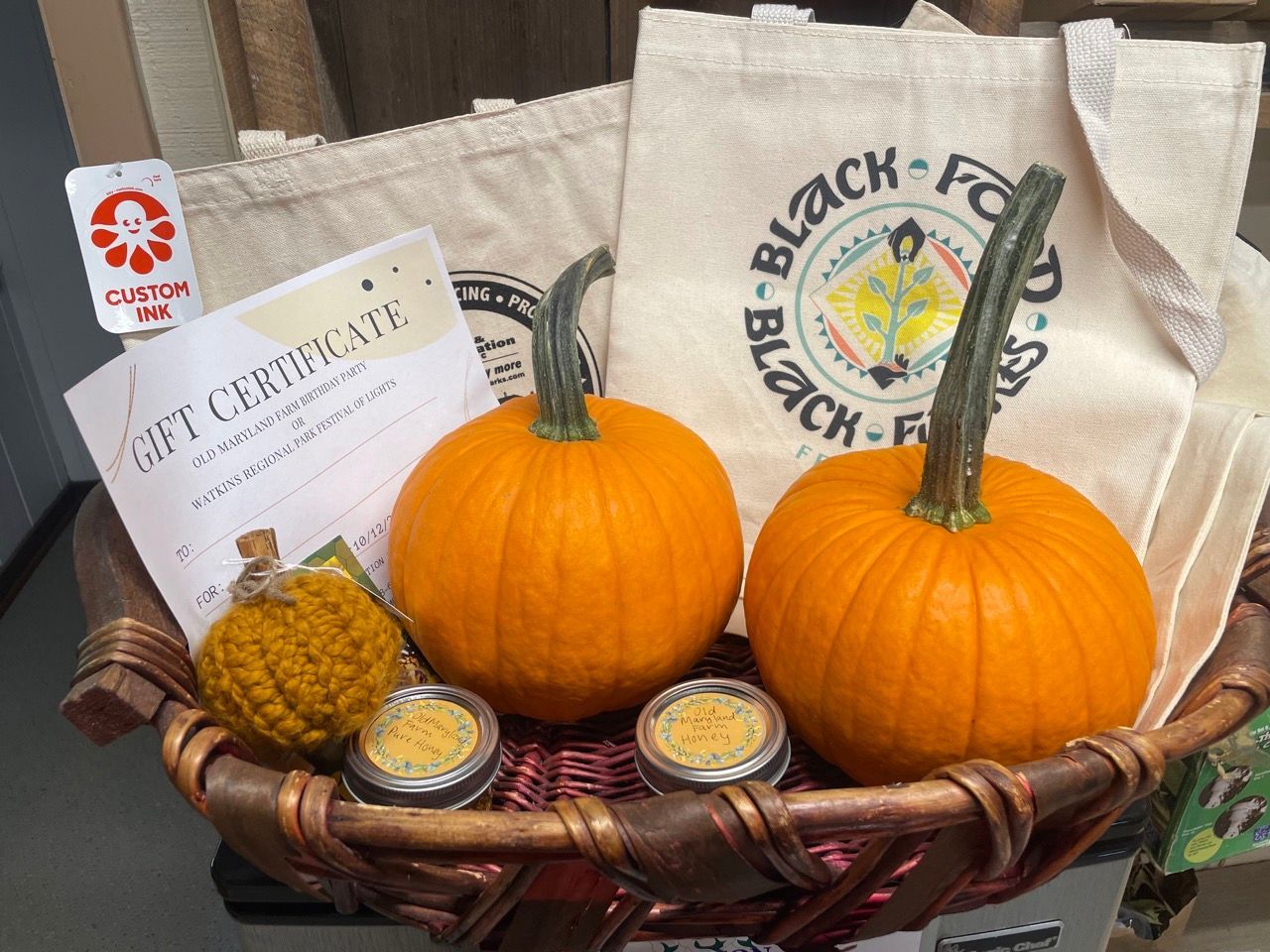 A basket filled with pumpkins and a gift certificate