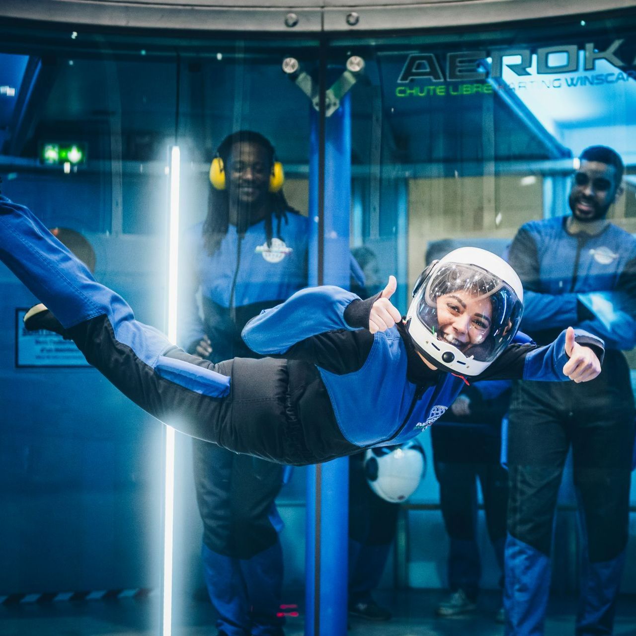 Une femme vole dans les airs dans un simulateur de chute libre