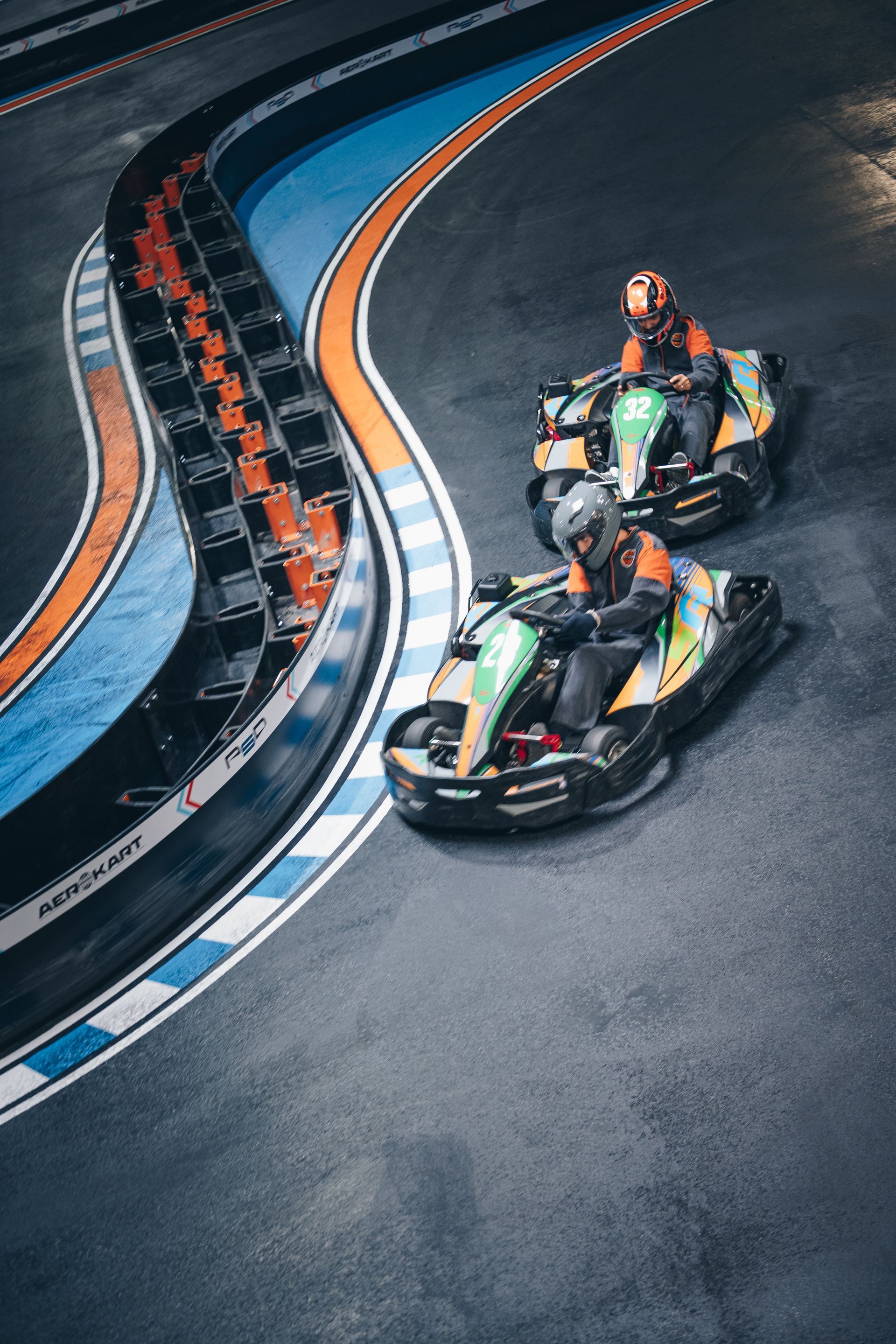 Deux personnes conduisent des karts sur une piste de course.