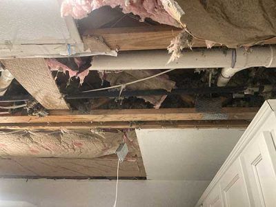 A room with a ceiling that is missing insulation and pipes.