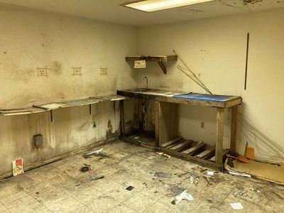 An empty room with a wooden table and a sink.