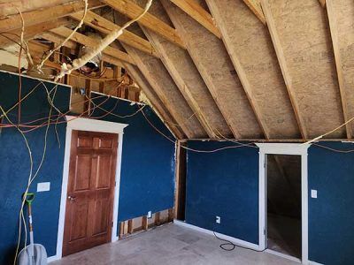A room with blue walls and a wooden ceiling under construction.