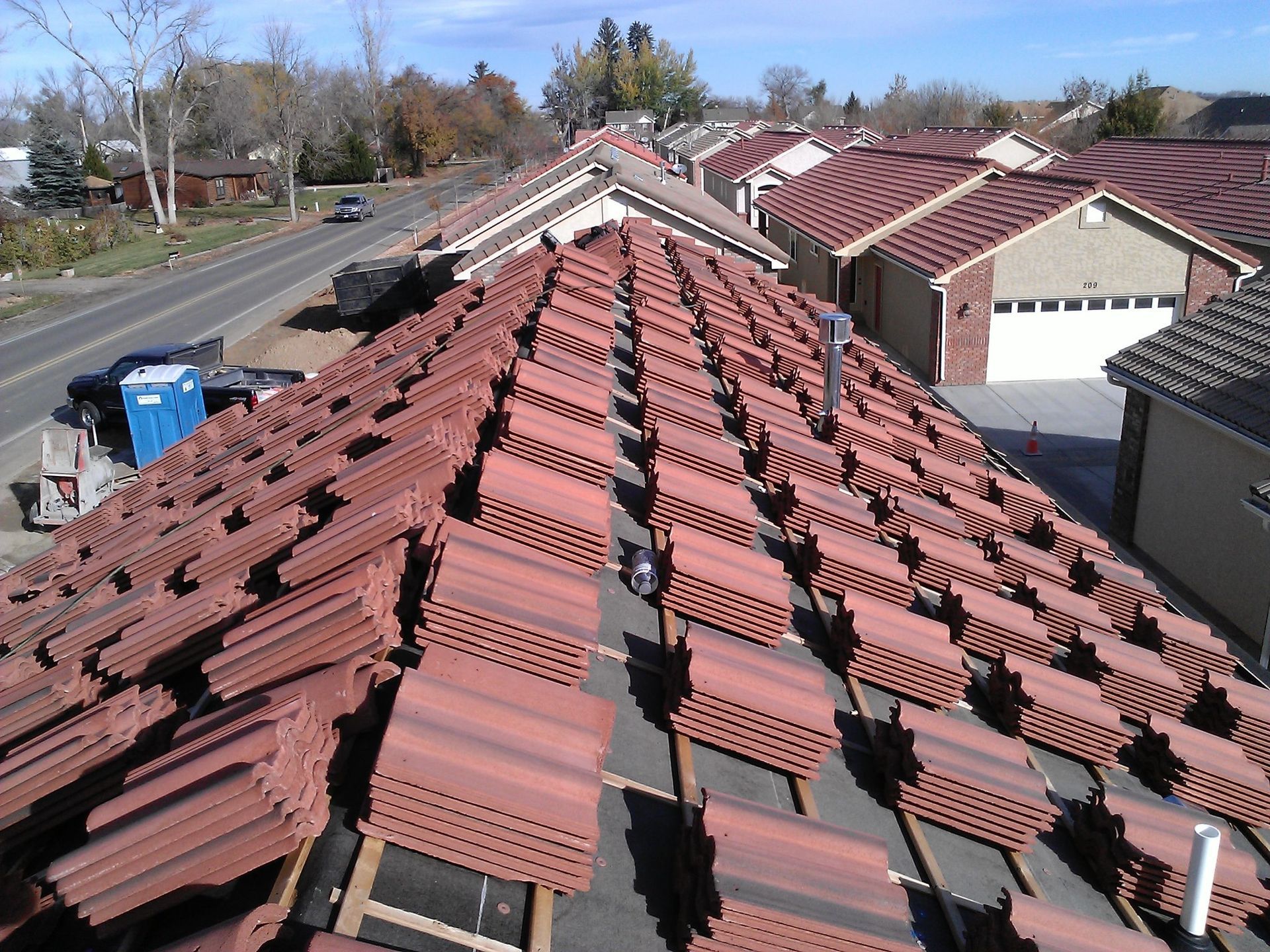 Rooftop with rows of red tiles on a residential building under a clear sky