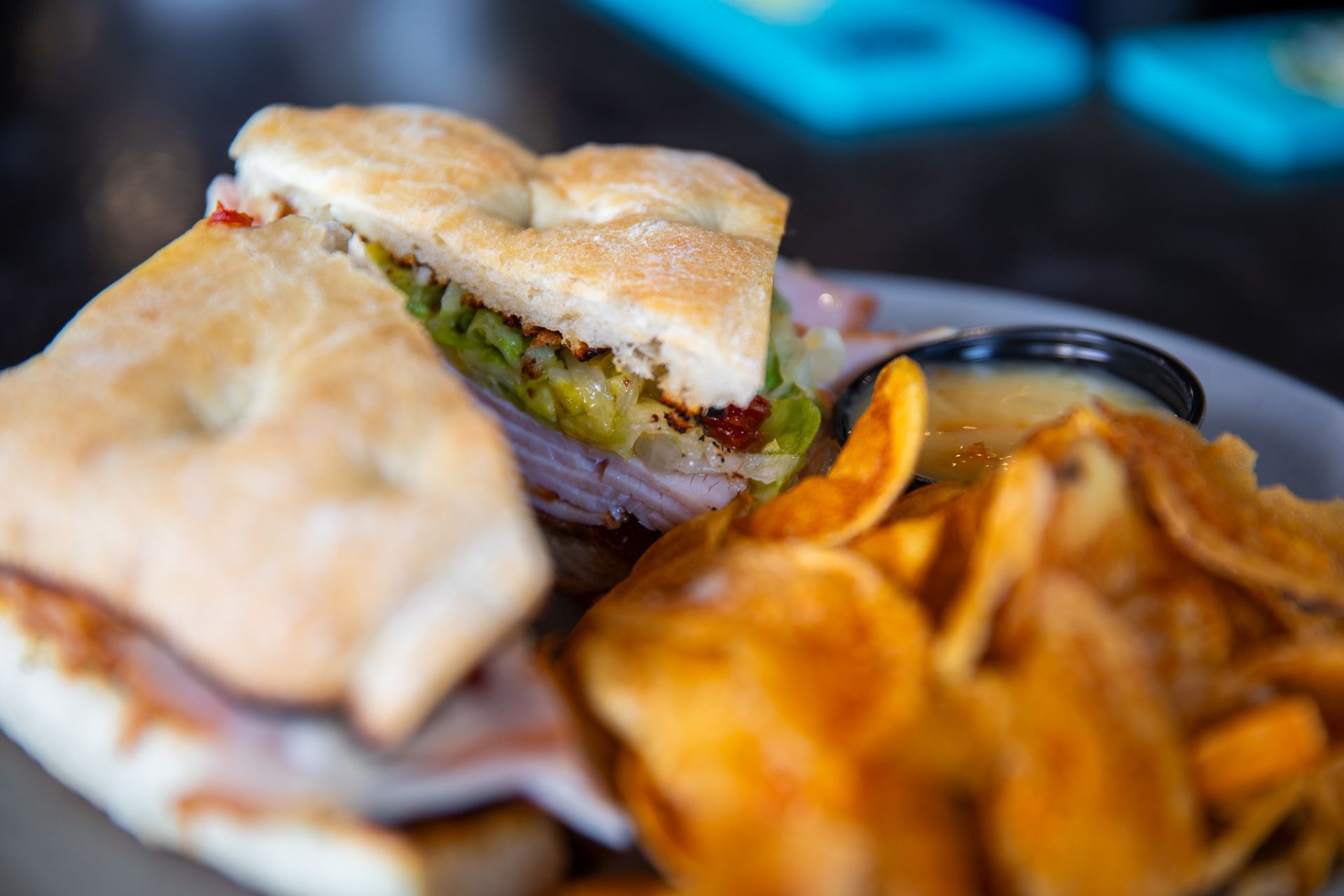 A close up of a sandwich and chips on a plate.