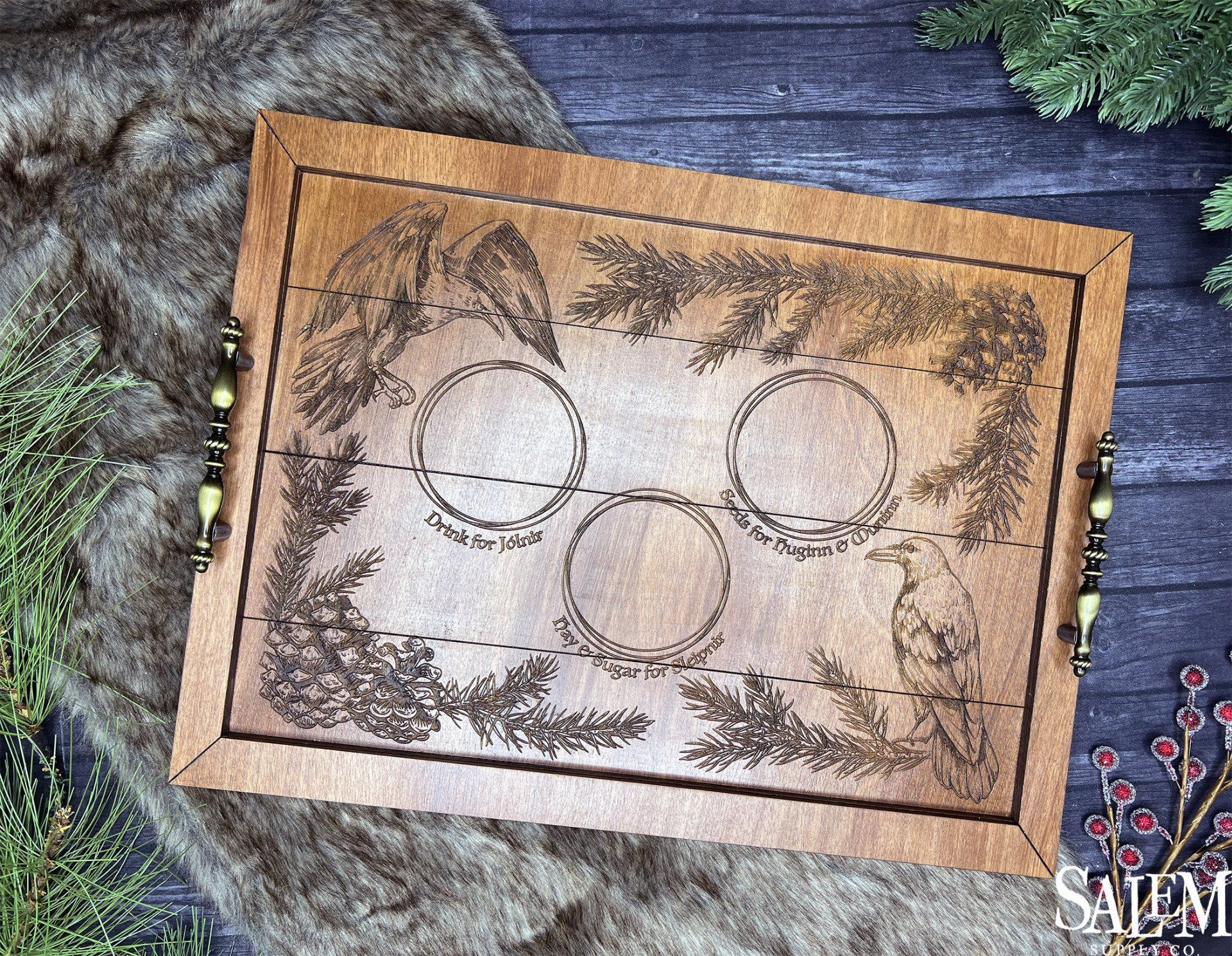 A wooden tray with three circles on it is sitting on a wooden table.