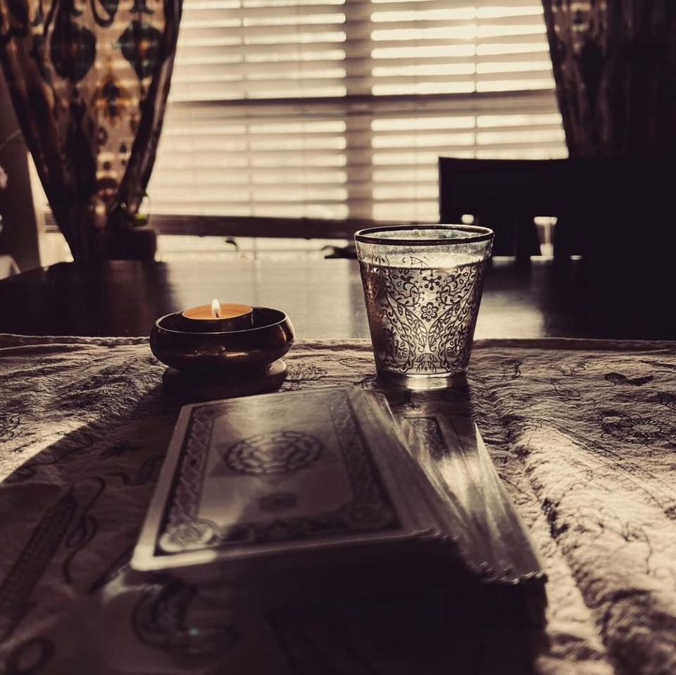 A candle and a glass of water on a table
