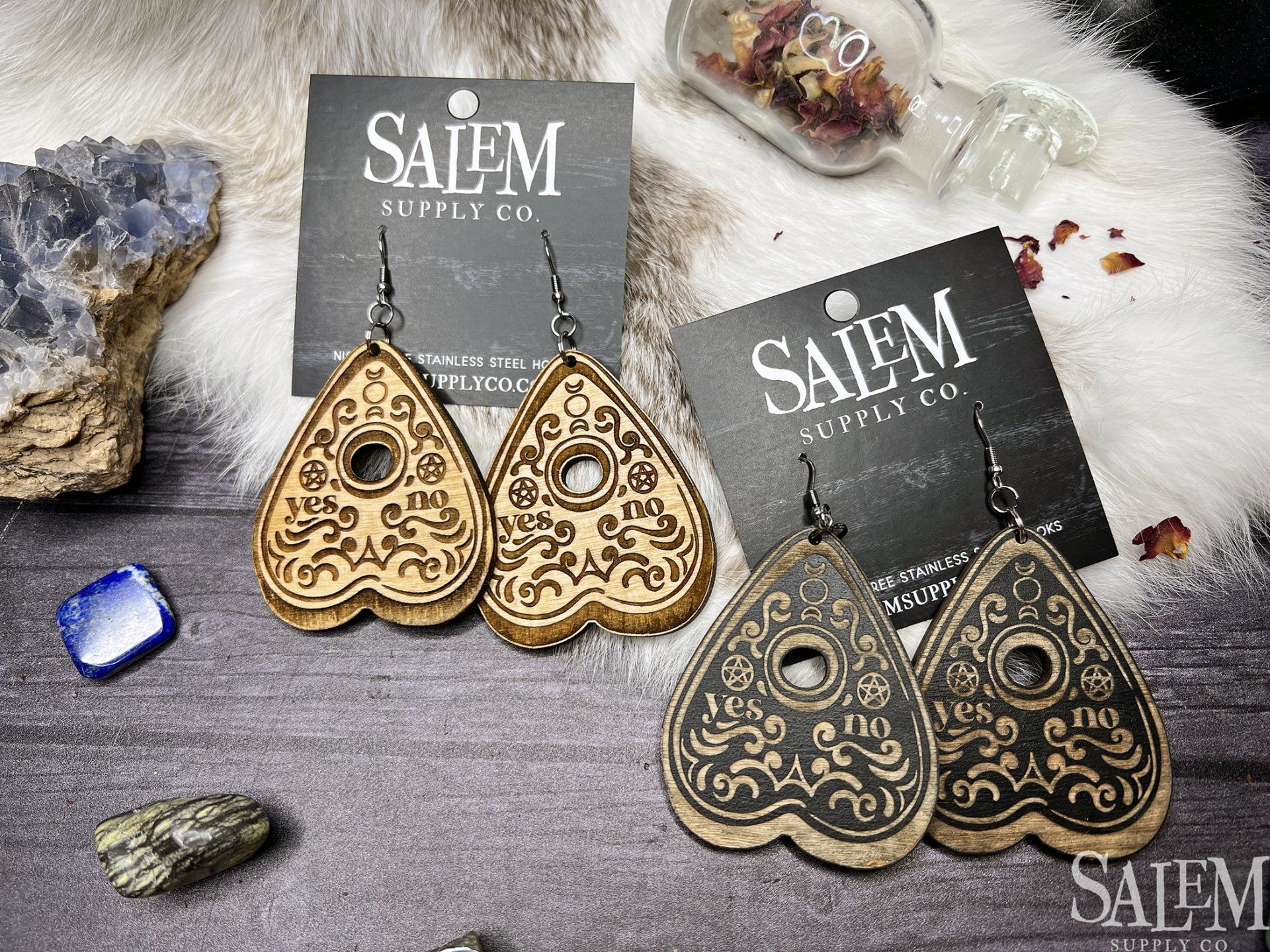 A pair of wooden earrings are sitting on top of a wooden table.