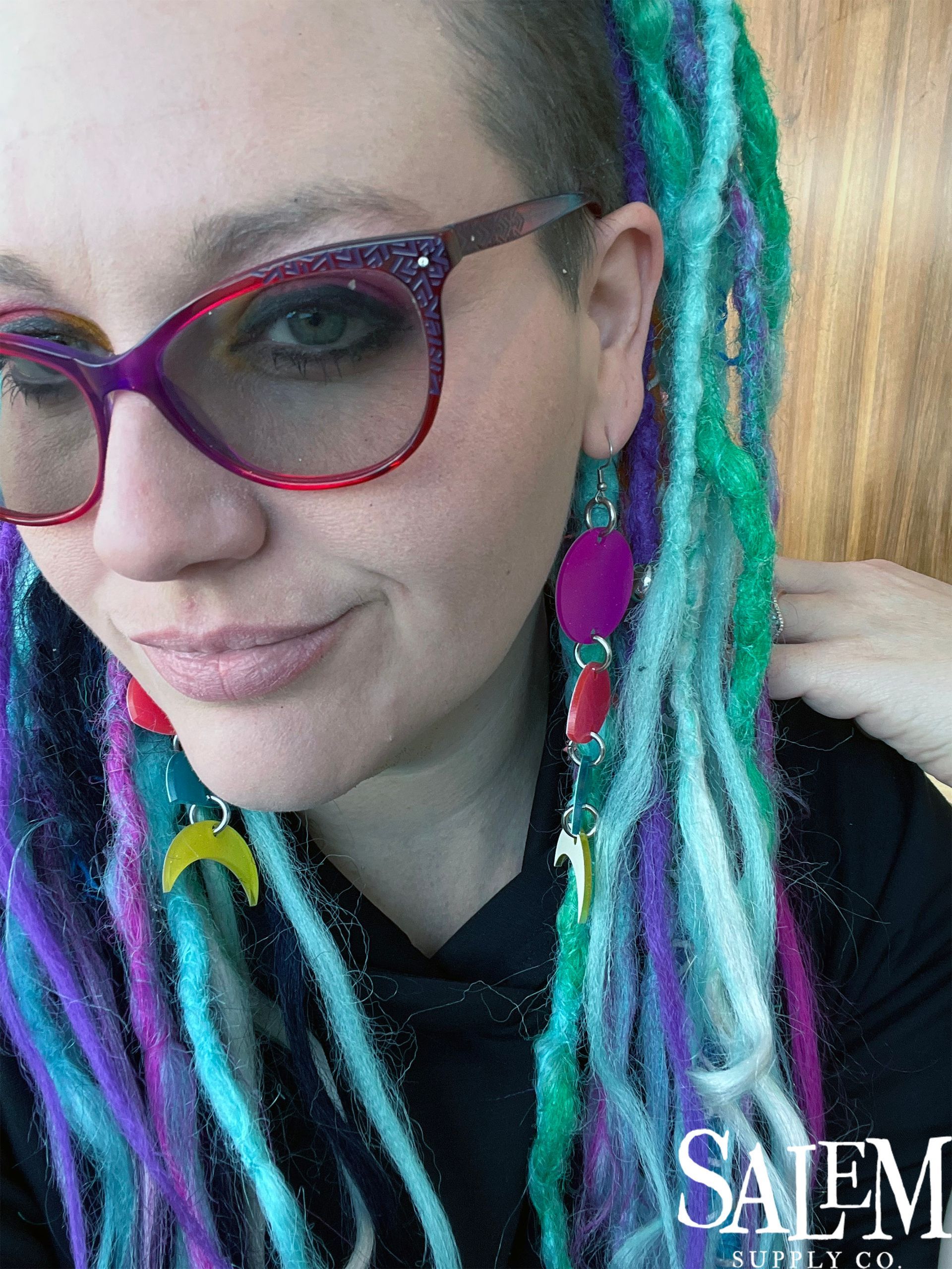 A woman with dreadlocks wearing glasses and earrings