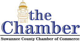 Logo for the Suwannee County Chamber of Commerce with a gold clock tower and blue text