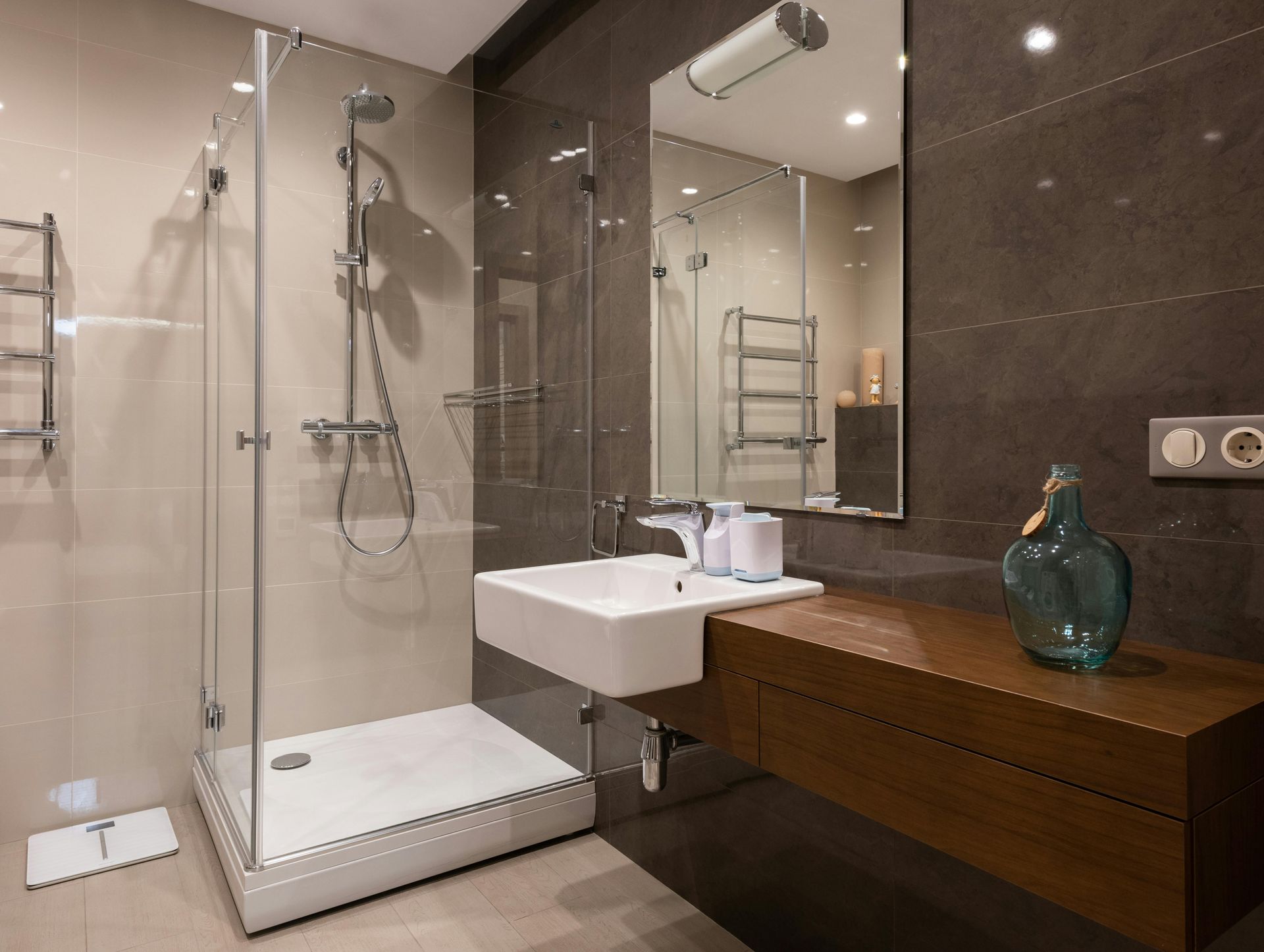 A bathroom under construction featuring large grey floor tiles, grey wall tiles, and accent walls with textured pink tiles.