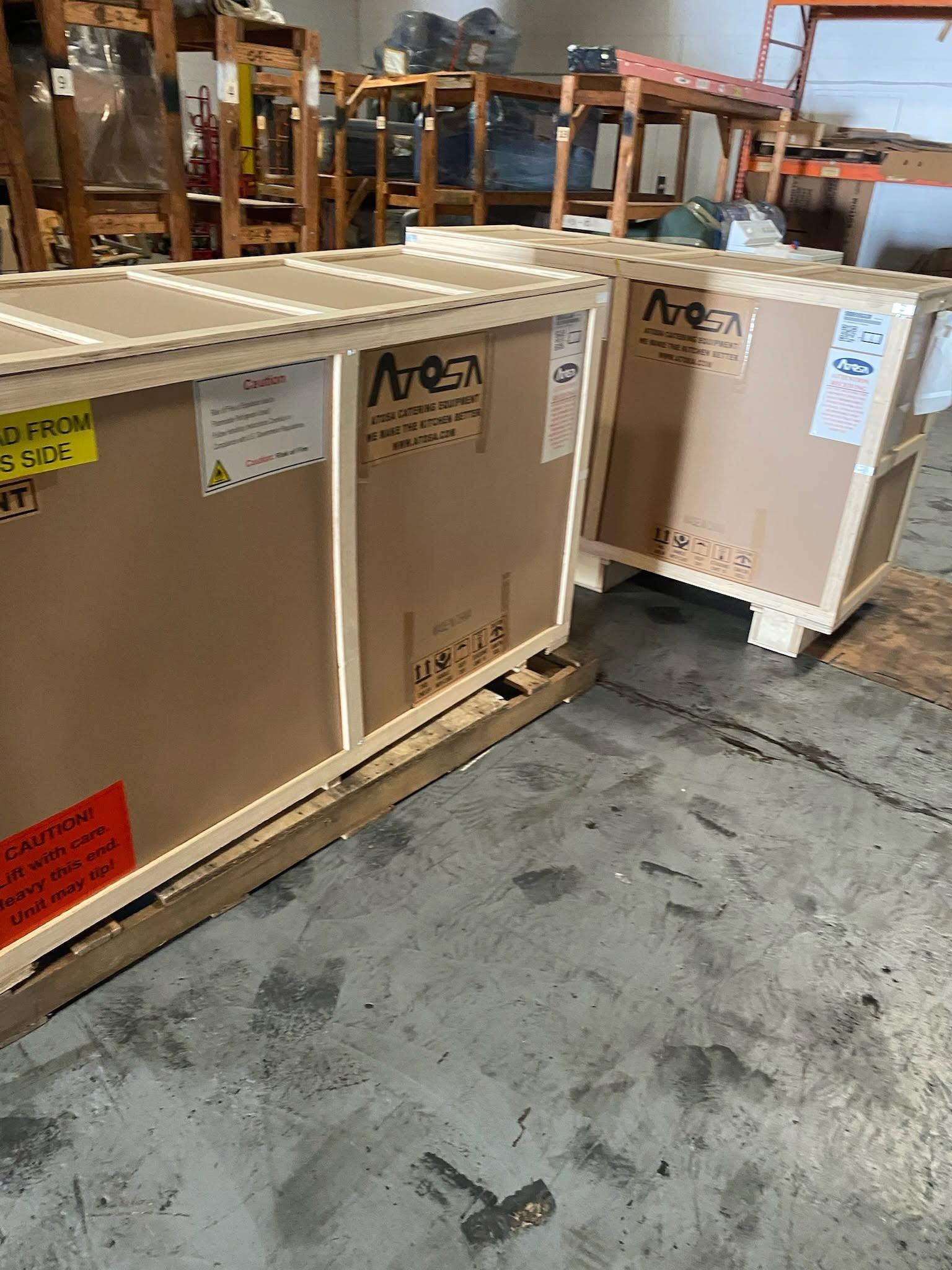 Large wooden shipping crates in a warehouse, one open with foam packaging inside.