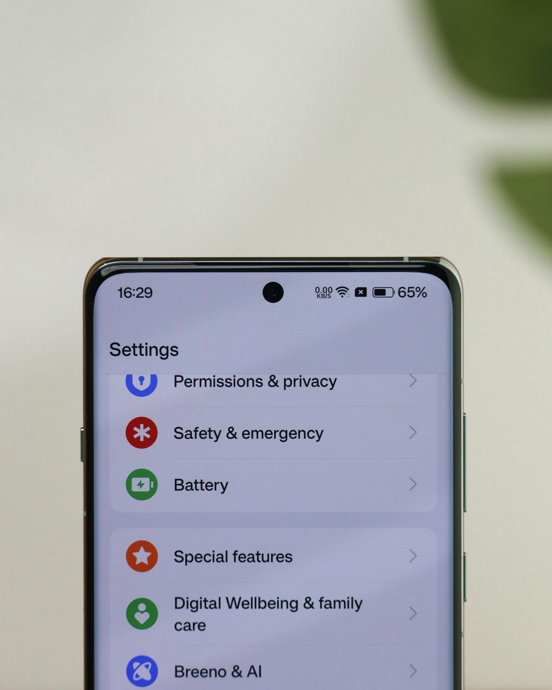 A smartphone showing the Settings menu with app icons on a light screen.