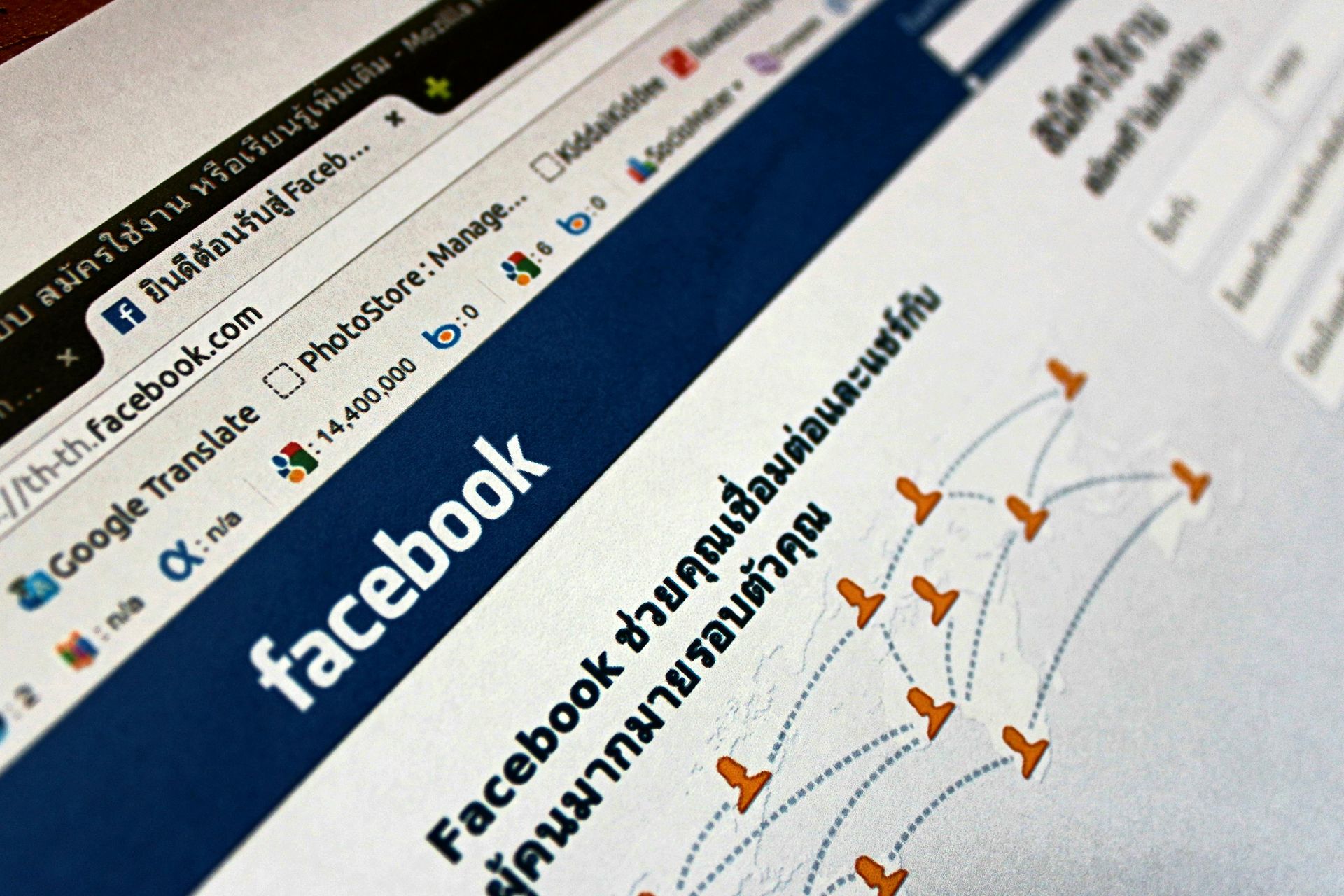 Facebook webpage on a laptop screen with Thai text and orange arrows highlighting content