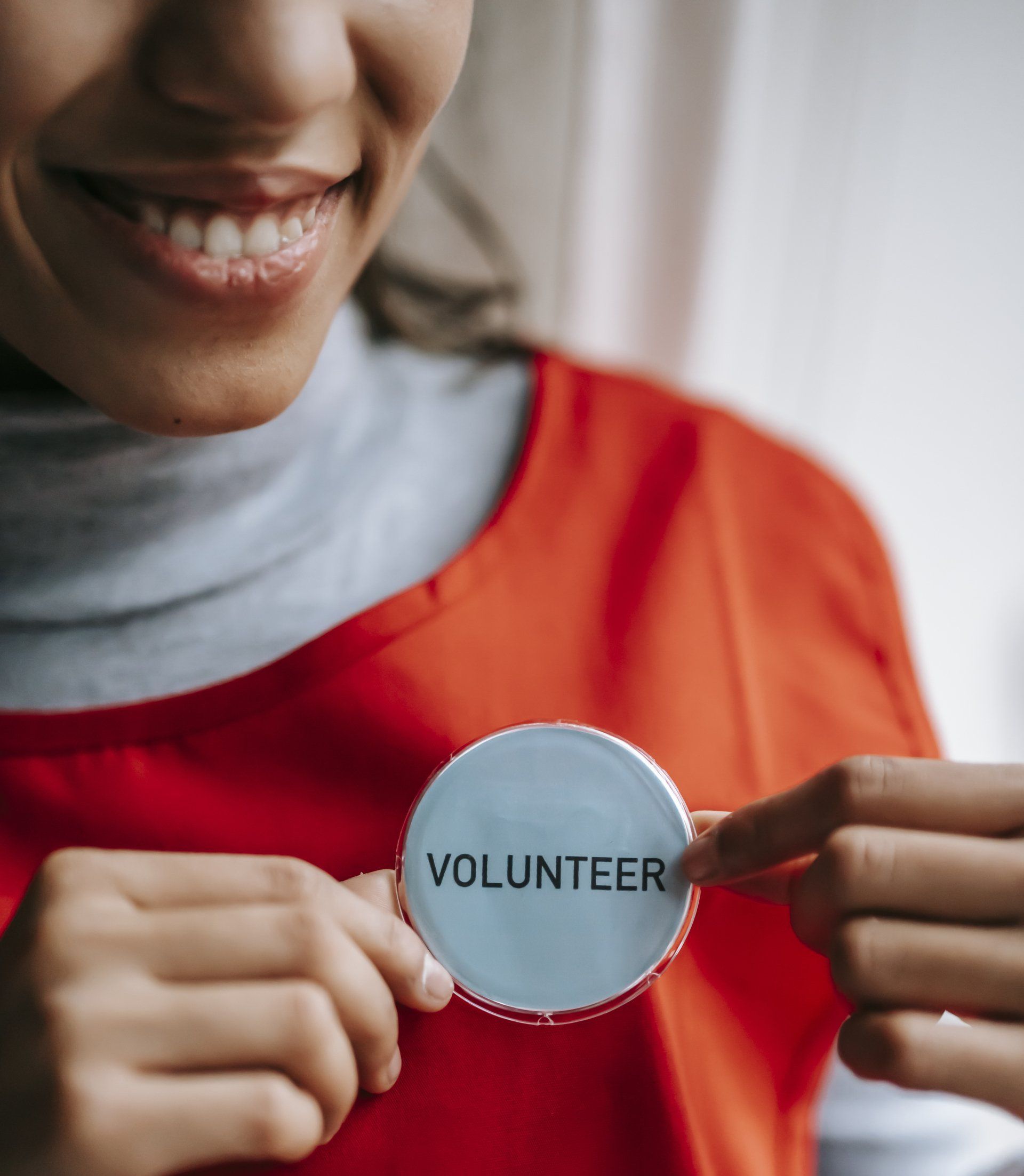 Person wearing an orange shirt, holding a 