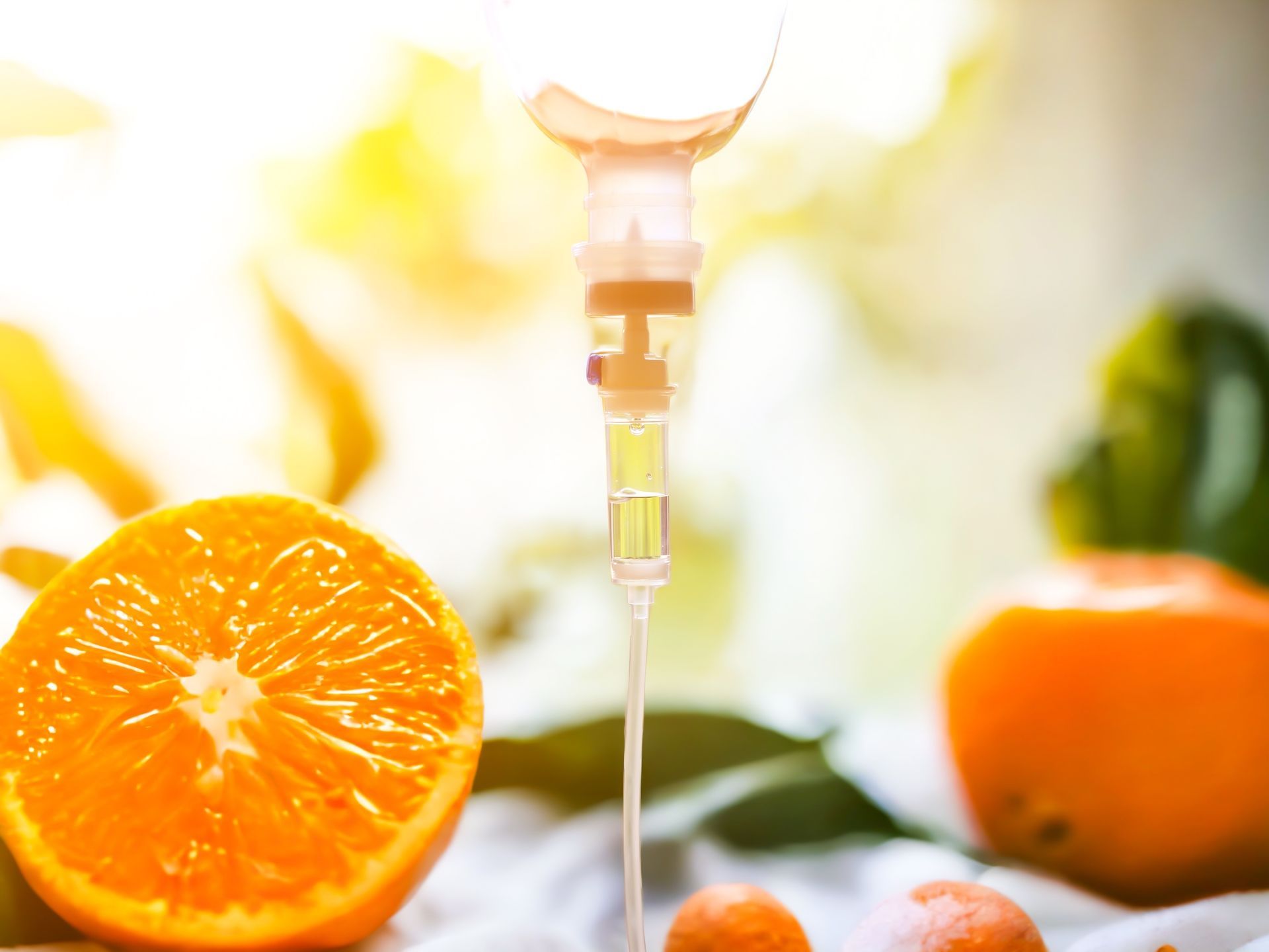 Orange slices and oranges with a dropper of juice against a bright background