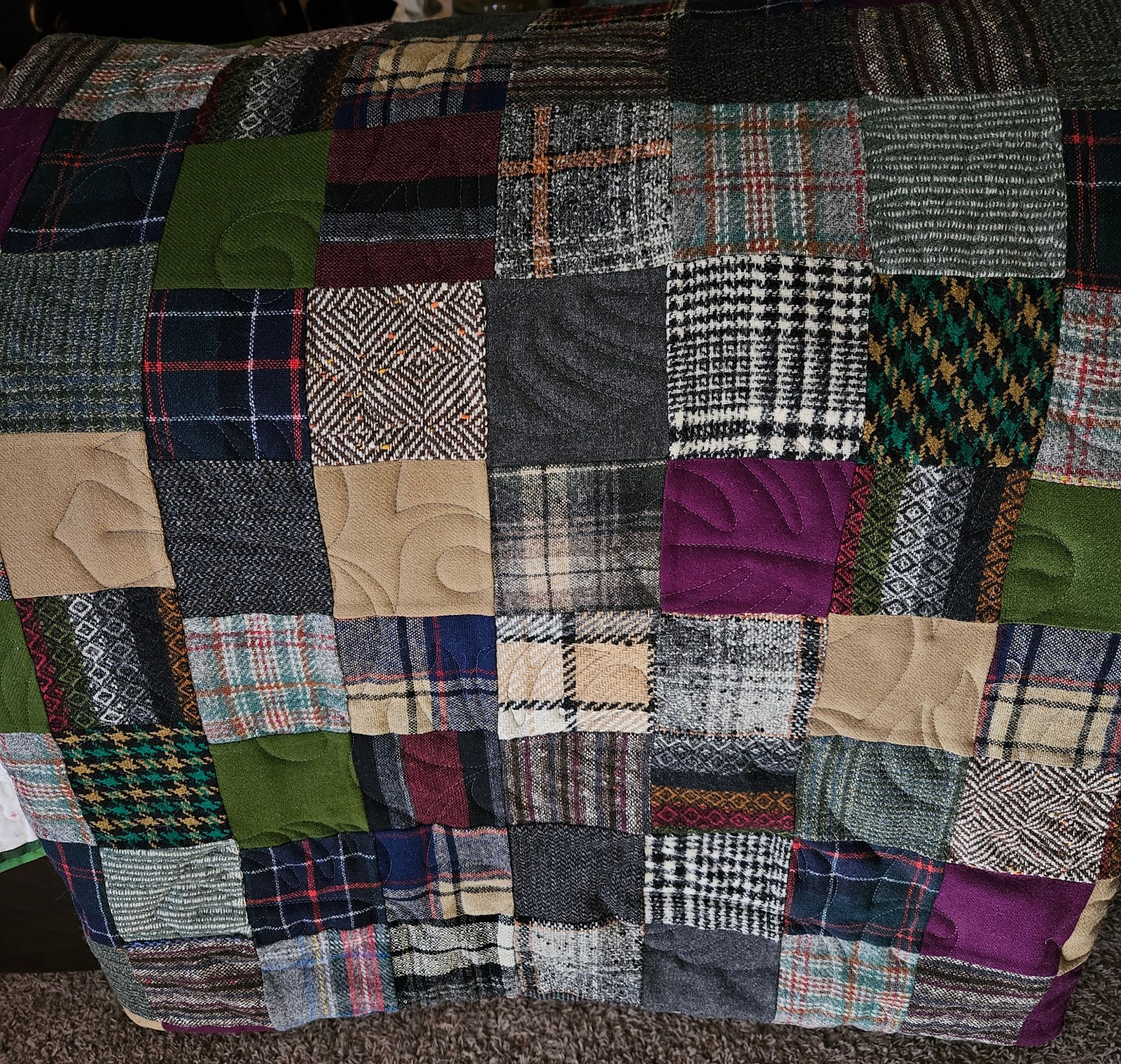 A patchwork quilt with purple and green squares