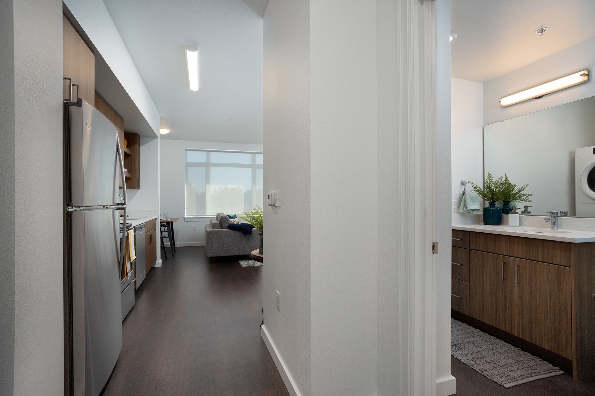A hallway leading to a kitchen and bathroom in a house.