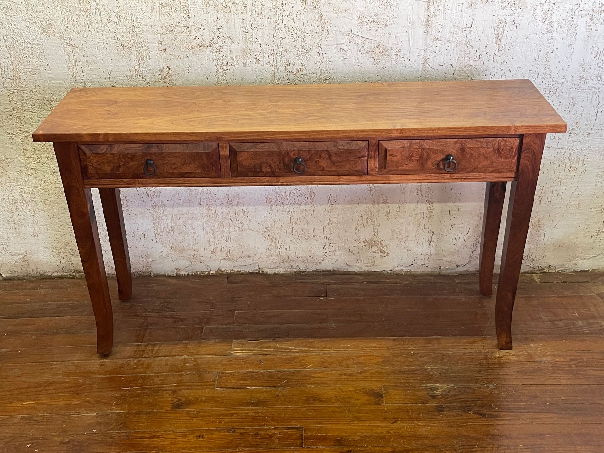 Wooden antique desk with two drawers against a plain wall