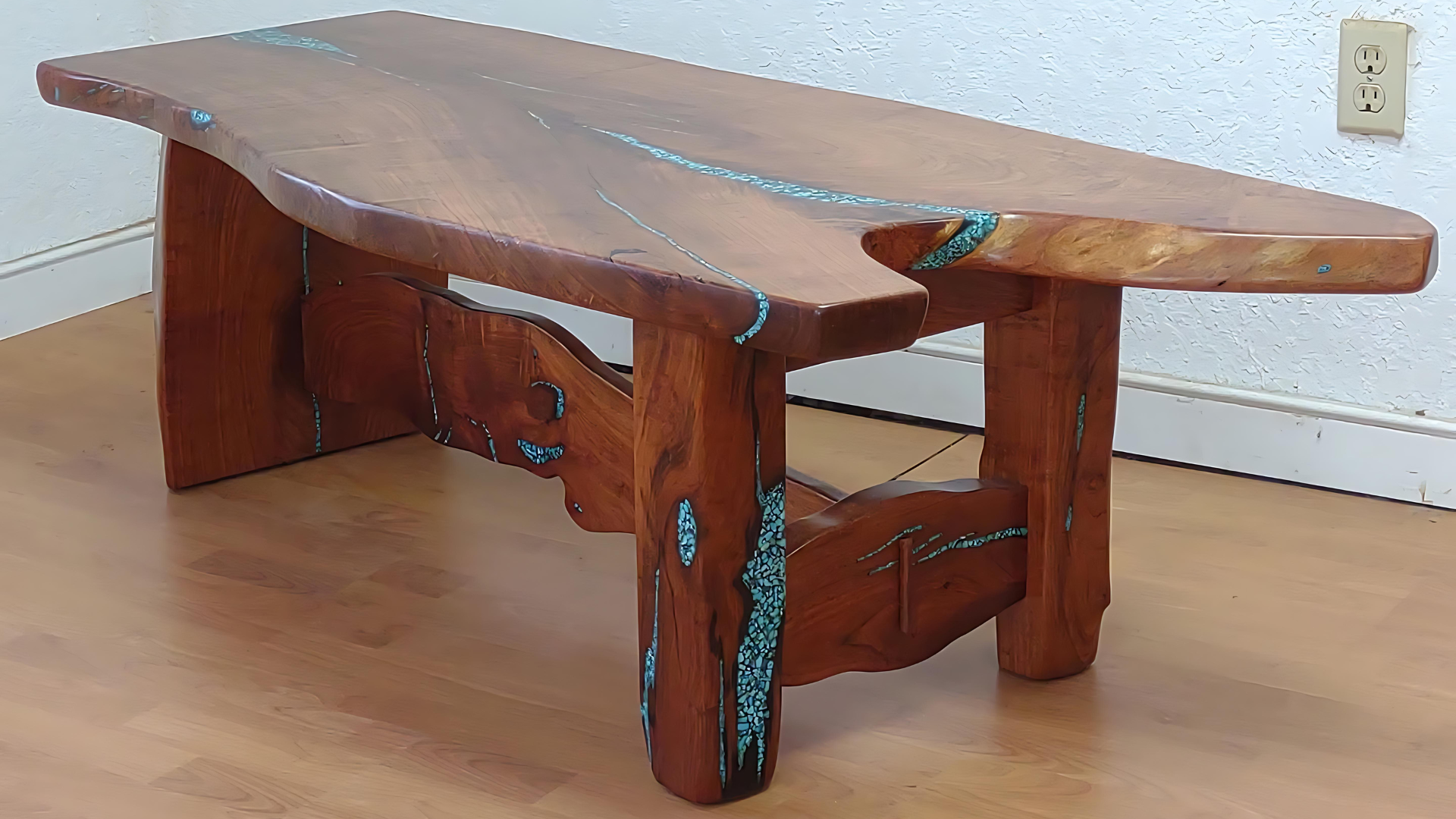 Rustic wooden coffee table with curved legs and turquoise inlay, on a hardwood floor