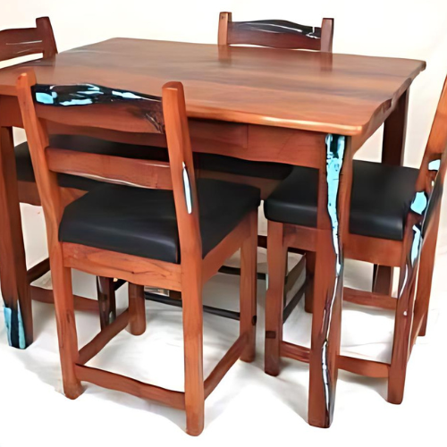 Wooden dining table with four black-cushioned chairs on a white background