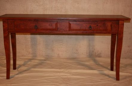 Wooden console table with two drawers and curved legs against a beige backdrop