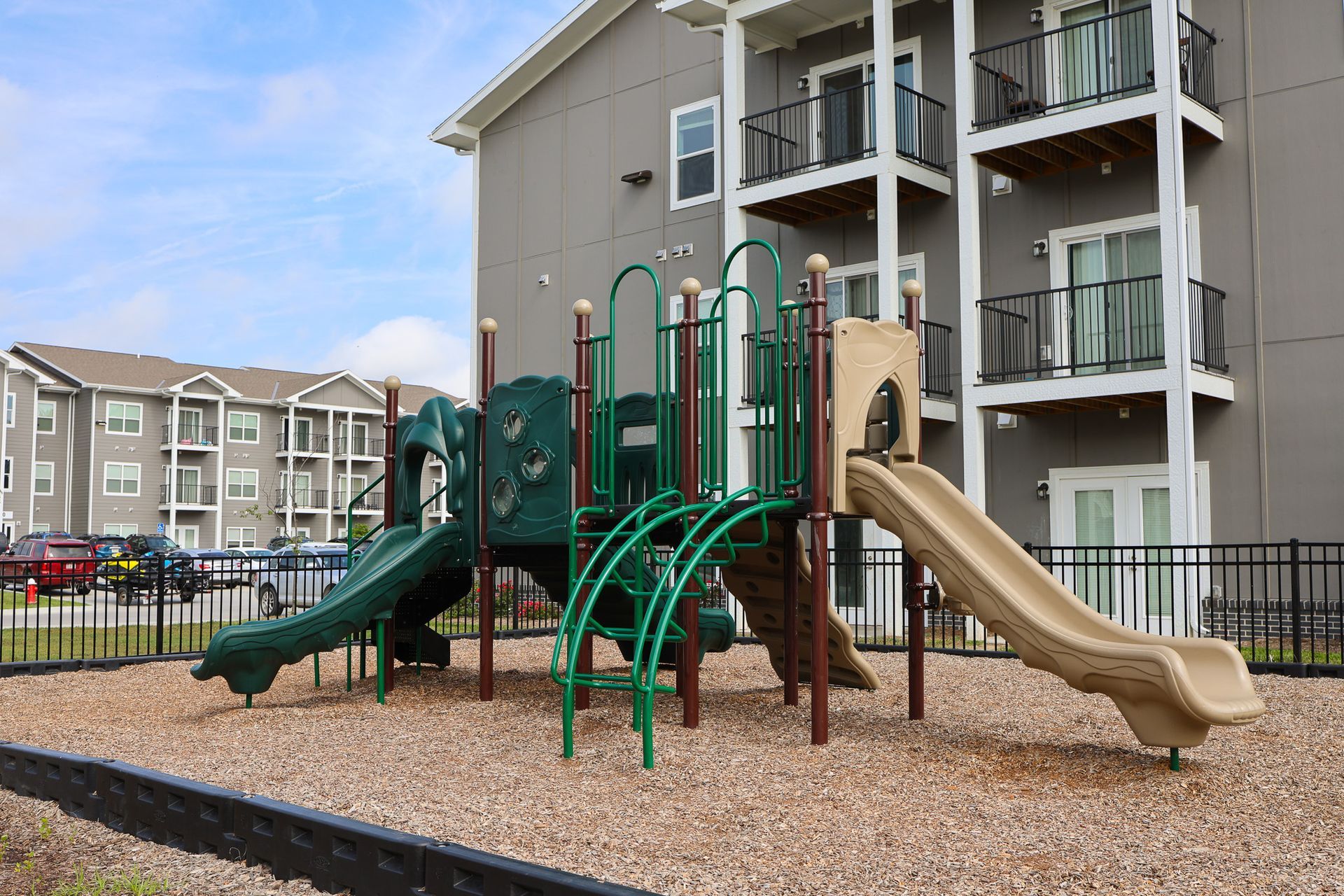 Two-Bedroom Affordable Apartments in Lincoln, NE - Union at Middle Creek - Playground With Green And Tan Slides, Climbing Structure, And Mulch Ground.