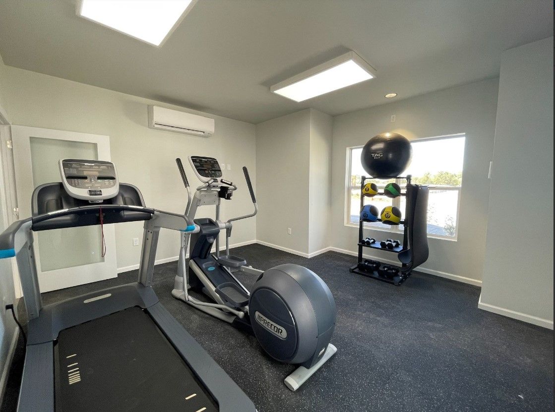 Lincoln, NE, Affordable Apartments Near Pioneer Park - Union at Middle Creek - Fitness Center With A Treadmill, Elliptical Machine, Free Weights, Medicine Balls, And A Large Window.