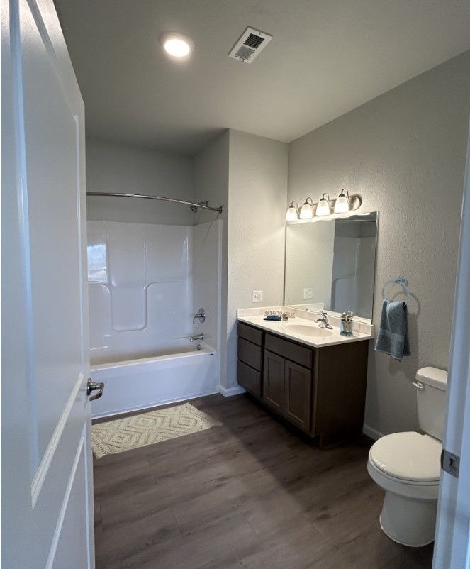 3 Bedroom Affordable Apartments in Lincoln, NE - Union at Middle Creek - Bathroom with 10-Foot Ceilings, Vinyl Plank Flooring, Bathtub, Shower Rod, Vanity, Light Fixtures, Mirror, Sink, and Towel Holder
