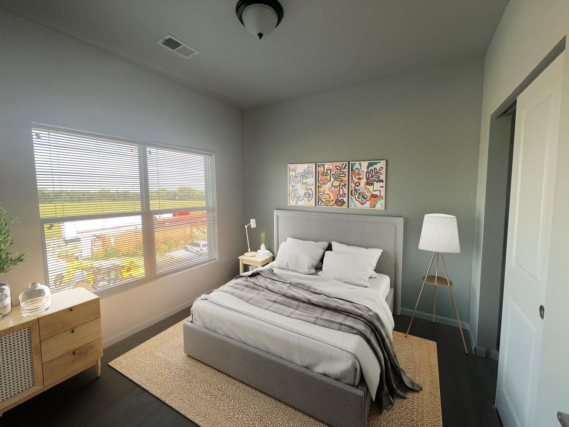 Pet-Friendly Affordable Apartments in Lincoln, NE - Union at Middle Creek - Bedroom With A Large Window, Gray Upholstered Bed With White Bedding, and Colorful Wall Art.