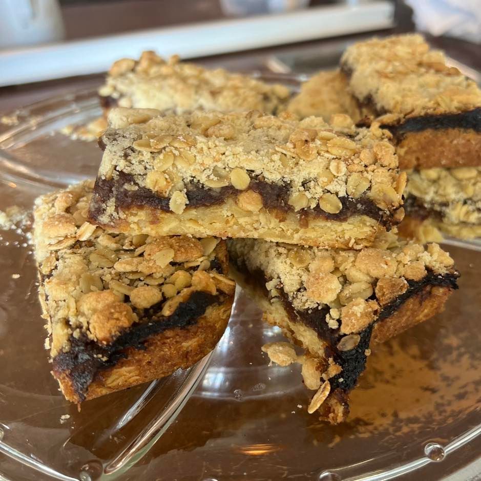 Oatmeal Date Bars on a Glass Plate; Golden Crumb Topping, Dark Filling — Memories Cafe @ Yorkeys Knob in Yorkeys Knob, QLD