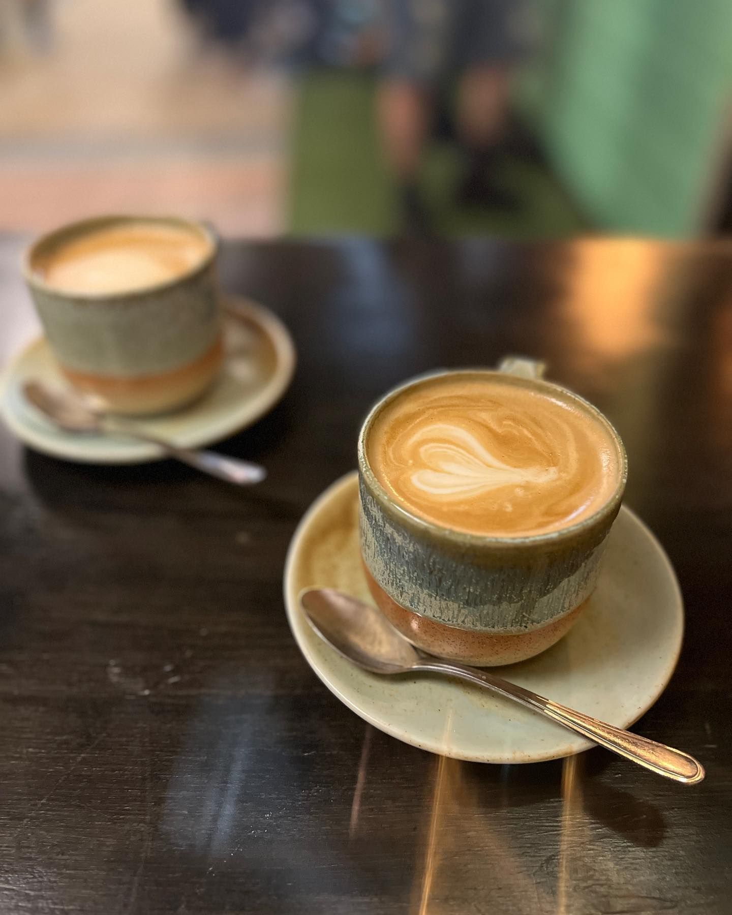 Two Lattes With Latte Art in Rustic Ceramic Mugs on Saucers — Memories Cafe @ Yorkeys Knob in Yorkeys Knob, QLD