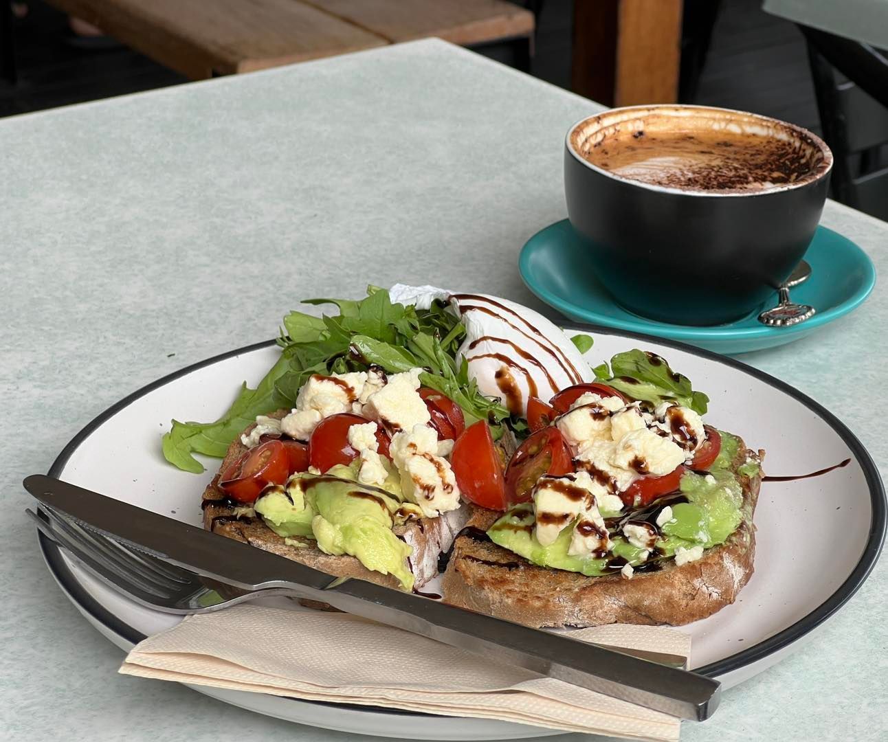 Avocado Toast With Tomatoes, and a Coffee on a Cafe Table — Memories Cafe @ Yorkeys Knob in Yorkeys Knob, QLD