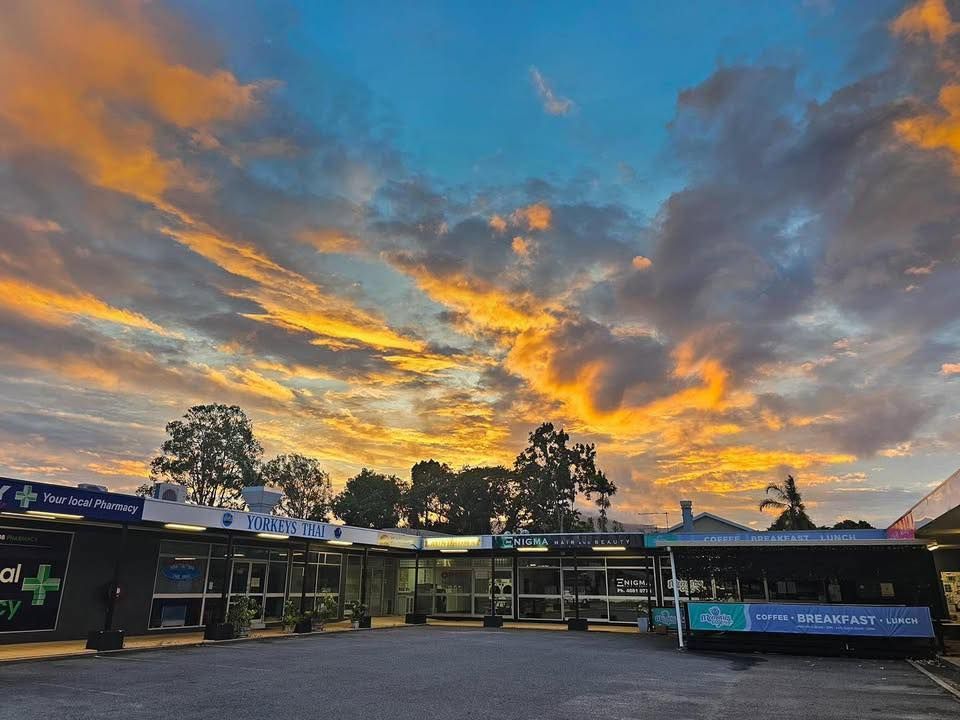 Sunset Over a Building Complex With a Blue, Black, and White Exterior — Memories Cafe @ Yorkeys Knob in Yorkeys Knob, QLD