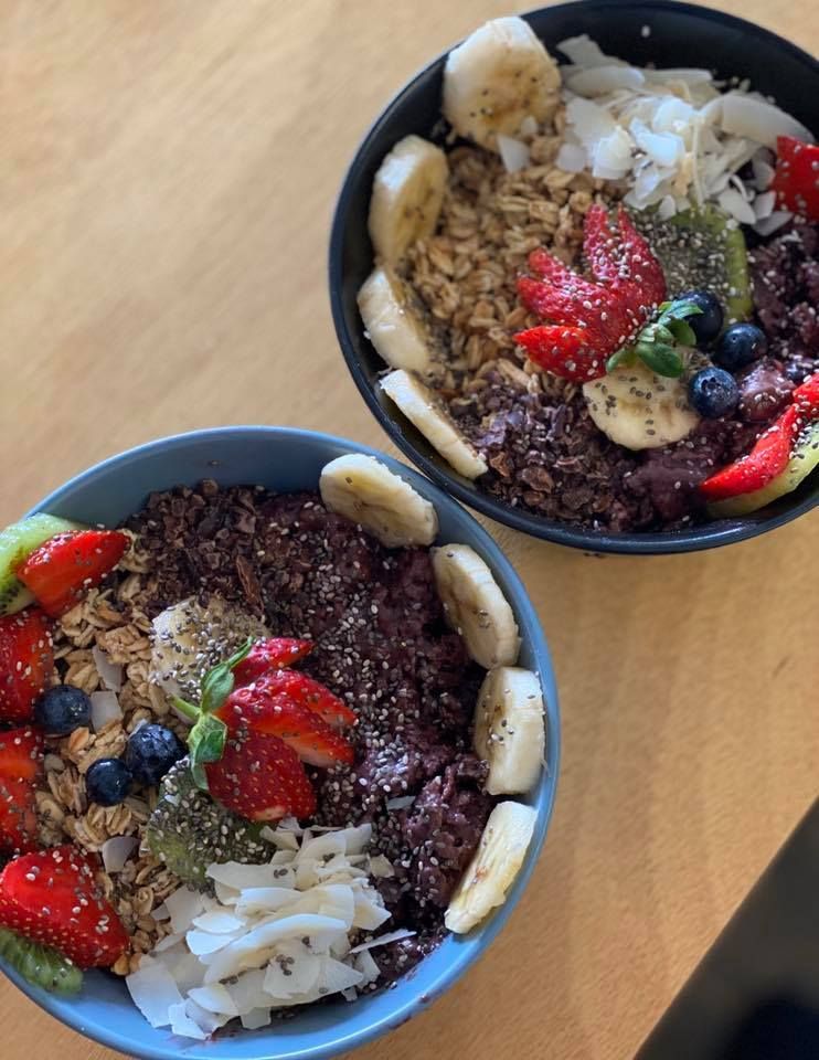 Two Acai Bowls With Granola, Fruit, and Coconut Flakes on a Wooden Table — Memories Cafe @ Yorkeys Knob in Yorkeys Knob, QLD