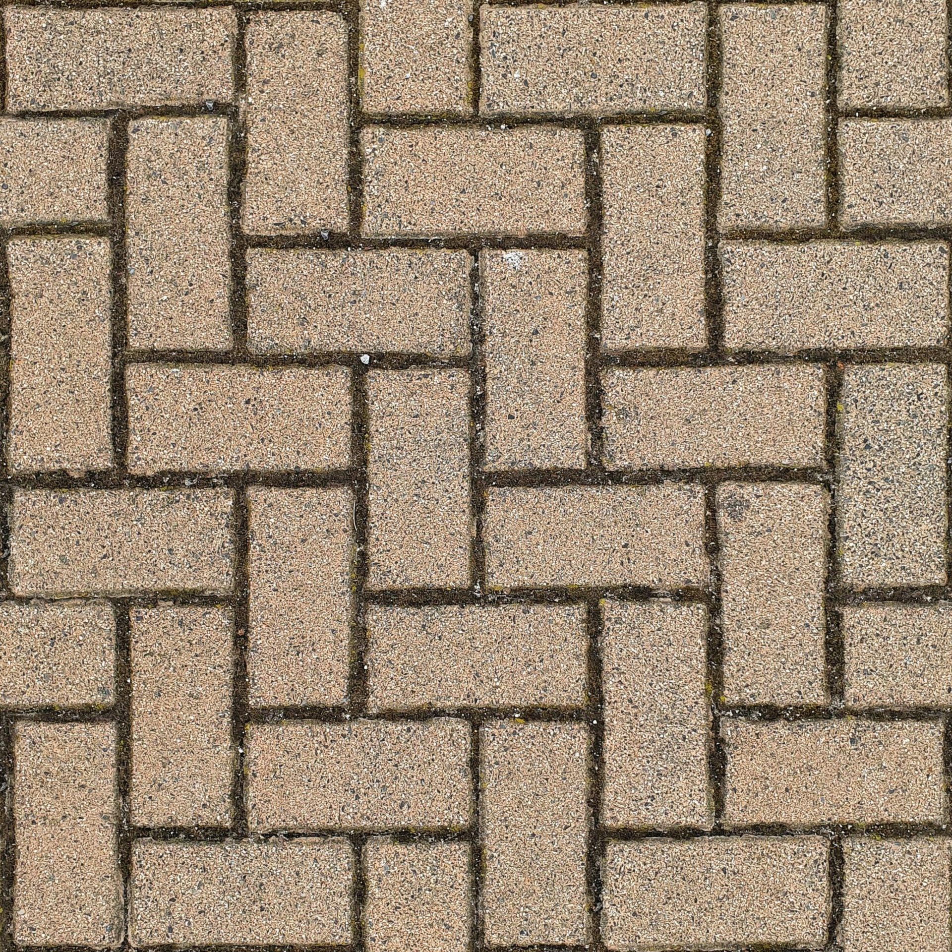 Interlocking tan and brown paver stones in a repeating geometric pattern