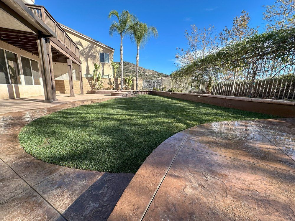 A patio with a lush green lawn in front of a house.