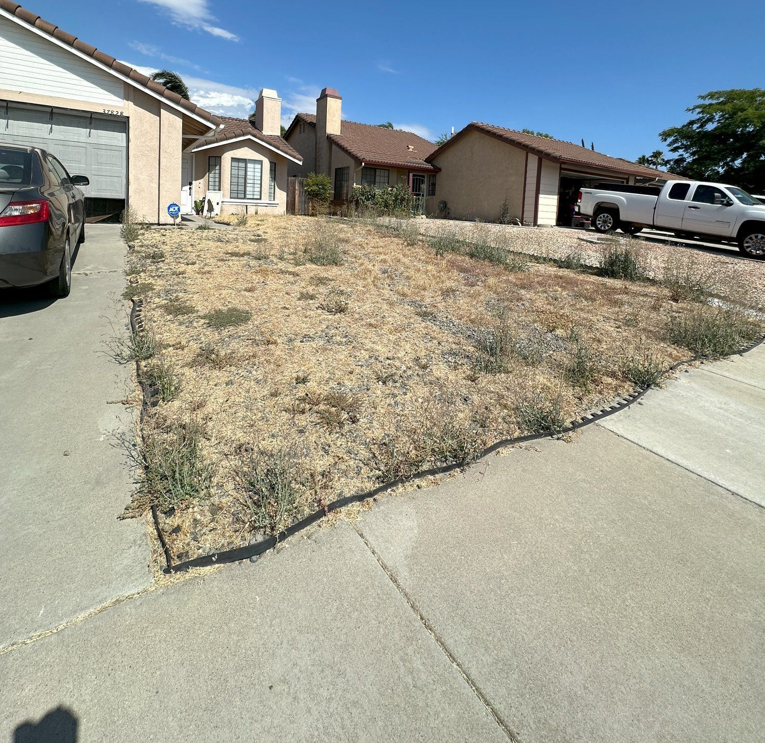 A car is parked on the sidewalk in front of a house