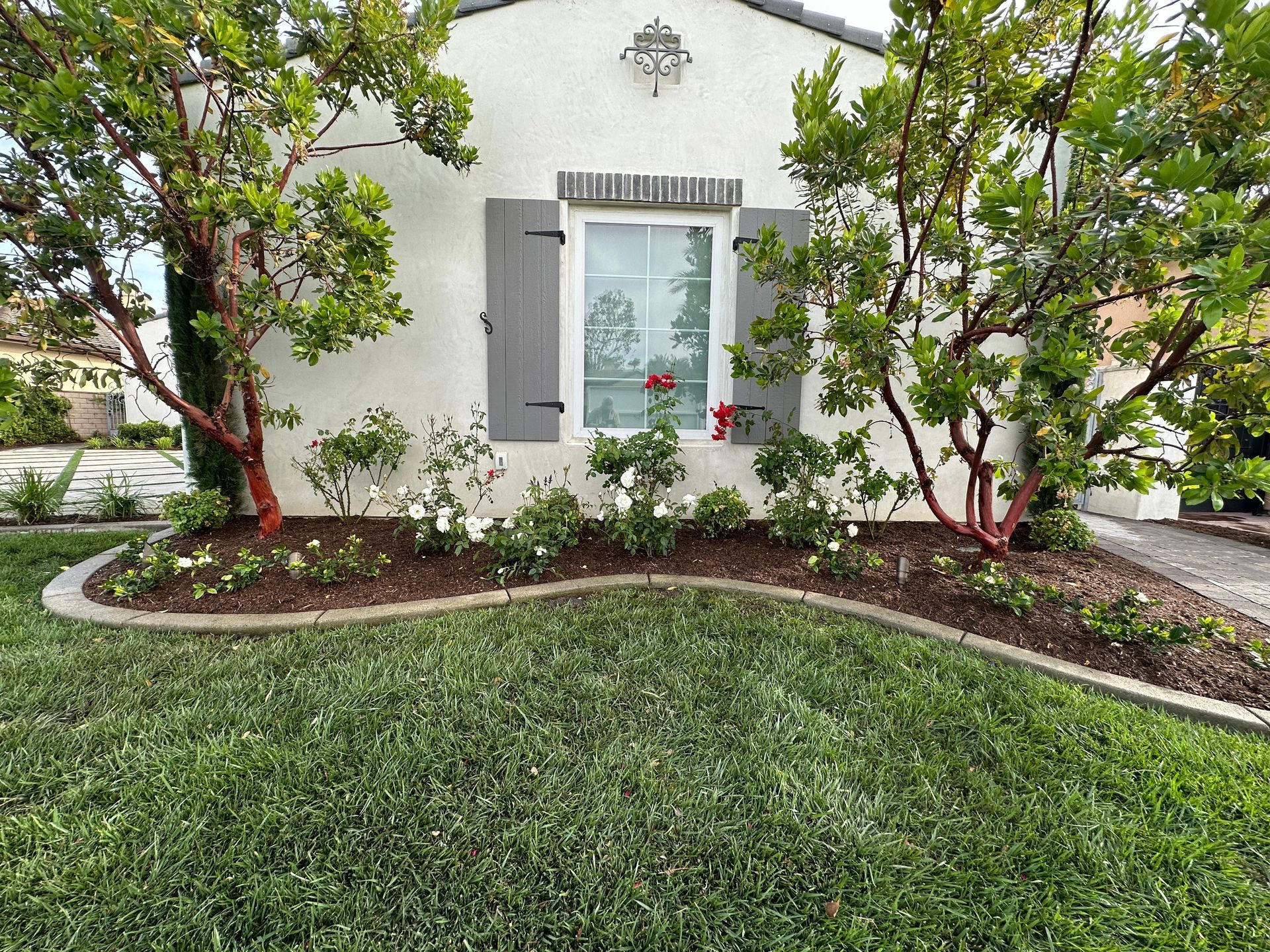 A white house with a lush green lawn in front of it.