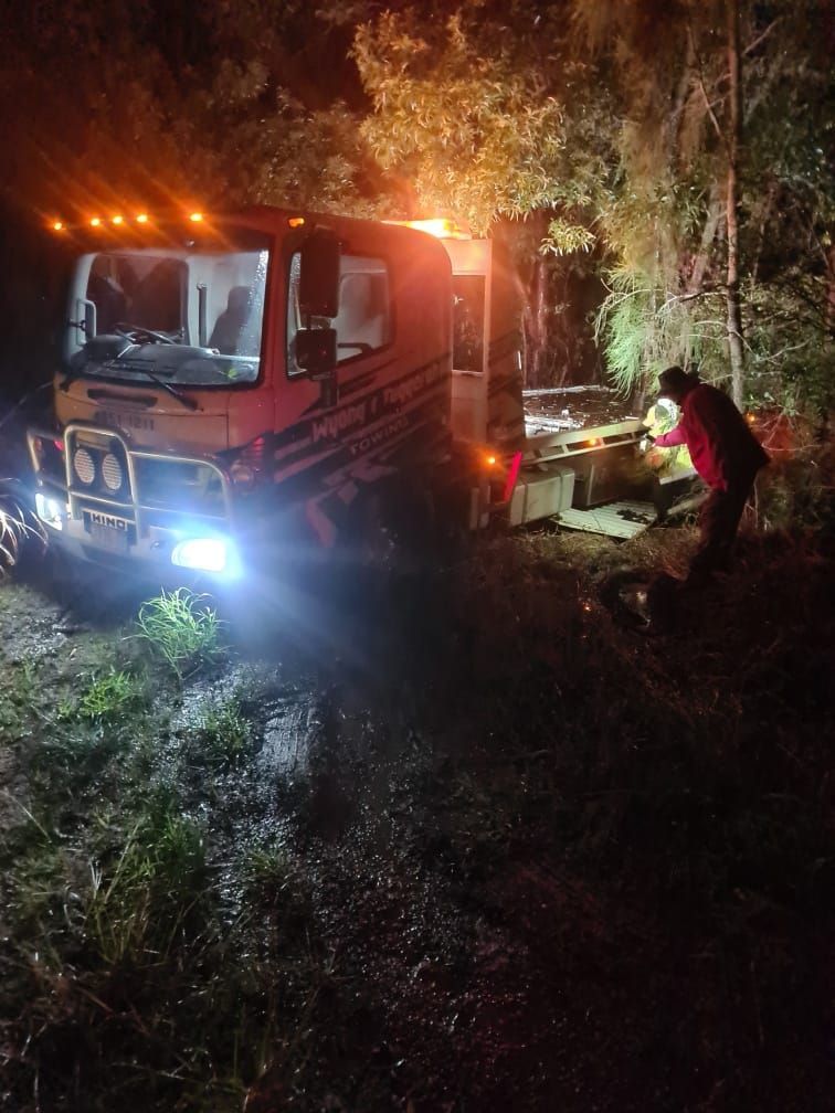 A Tow Truck is Parked in the Woods at Night — Wyong and Tuggerah Towing Service in Tuggerah, NSW