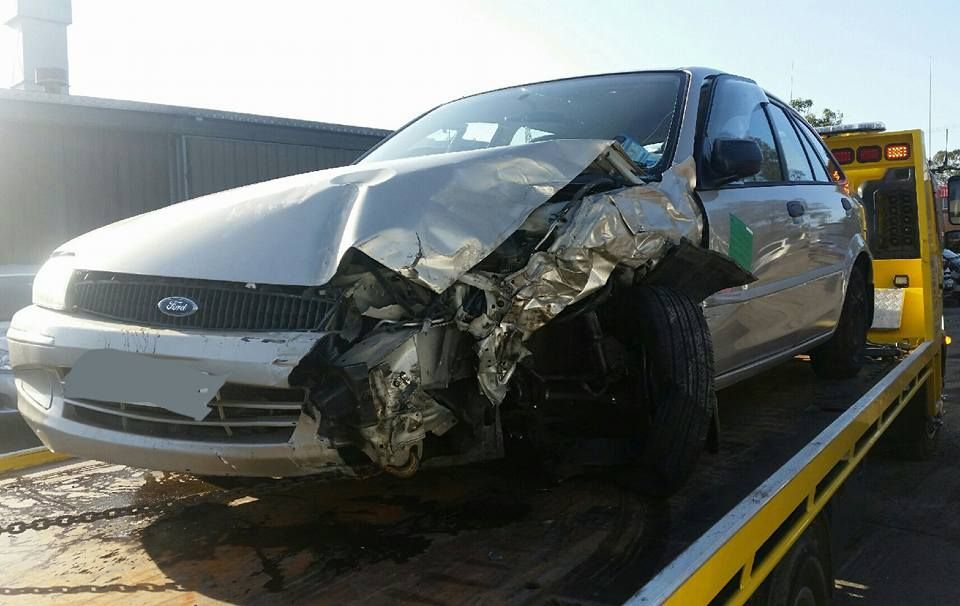 A Damaged Ford Car is on a Tow Truck — Wyong and Tuggerah Towing Service in Woy Woy, NSW