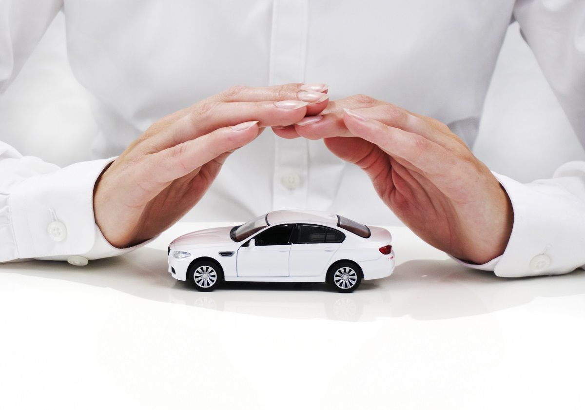 A person is holding a toy car in their hands.