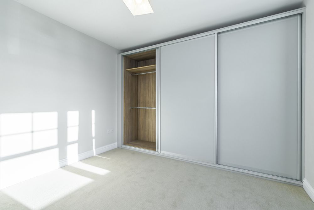 A Room Featuring a Large Floor-to-Ceiling Sliding-door Wardrobe — Sams Glass Solutions in Proserpine, QLD