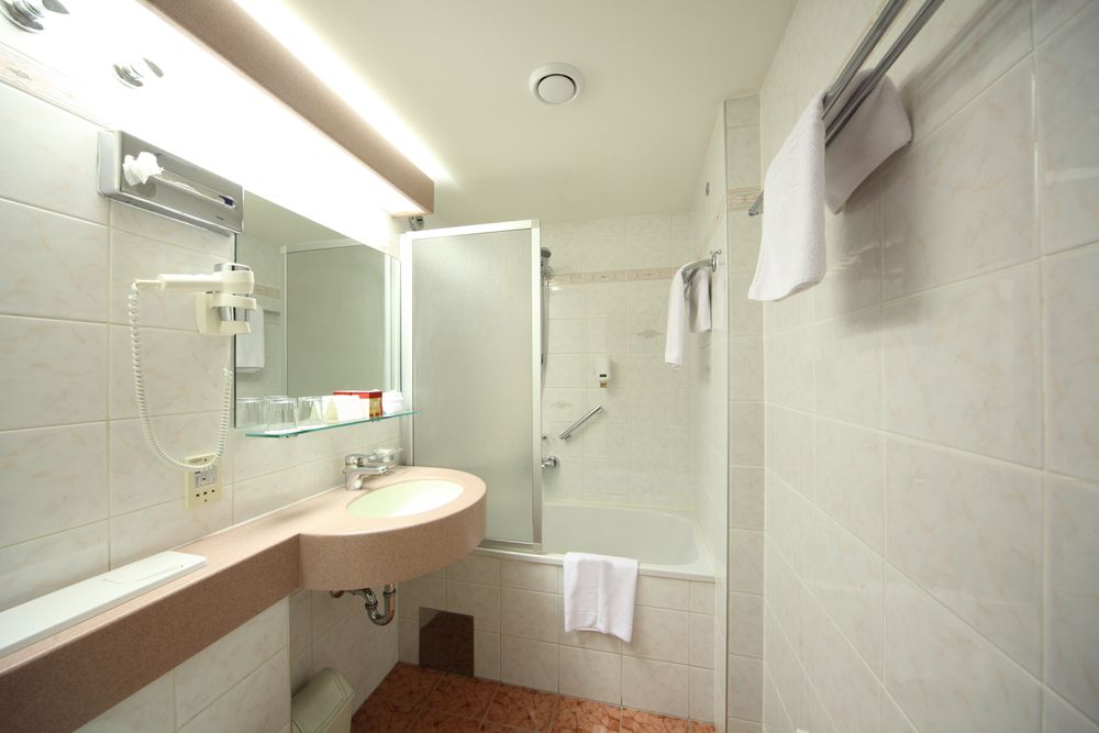 A Clean, Modern Bathroom With a Sink and Shower Screen — Sams Glass Solutions in Proserpine, QLD