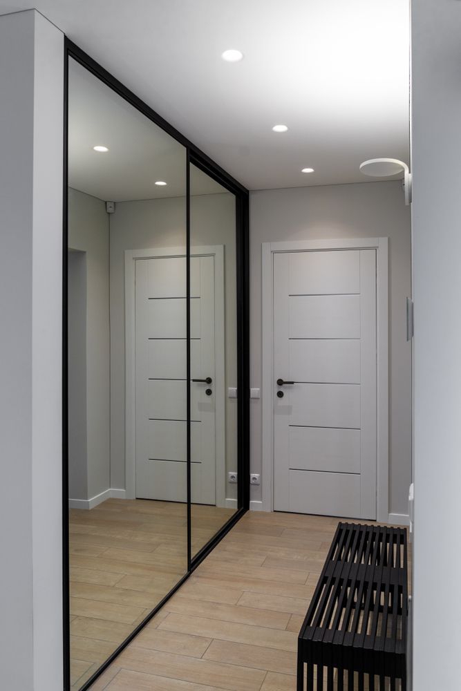 Hallway With Mirrored Closet, White Doors, and Black Bench — Sams Glass Solutions in Bowen, QLD
